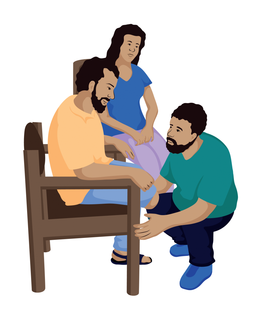 A service provider is kneeling in front of a man with a below knee amputation, who is sitting in a chair. The service provider is looking at the man’s leg. Seated next to the man is a woman who is watching closely.
