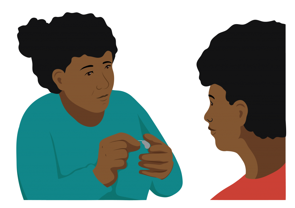 A service provider showing a woman how to use a hearing aid.