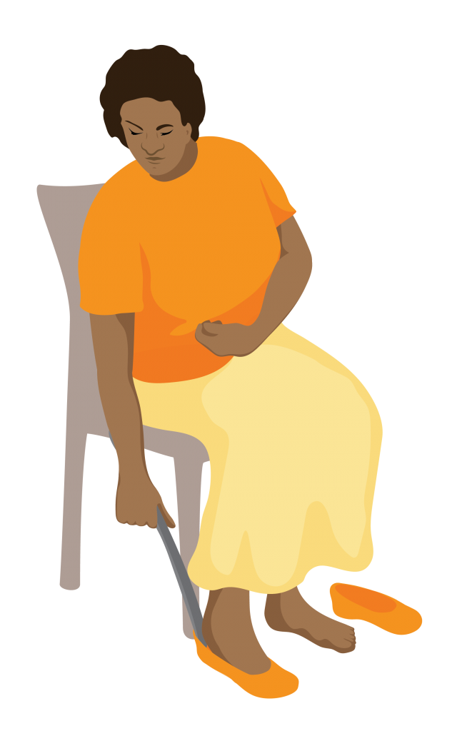Aida sits on a chair and uses a long handled shoe horn to put on a shoe.
