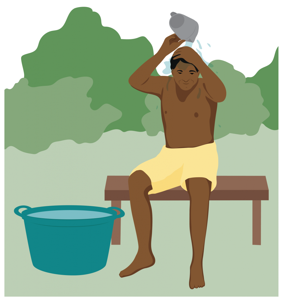 A man in shorts sits on a bench and pours a jug of water over his head. A large tub of water sits next to him.