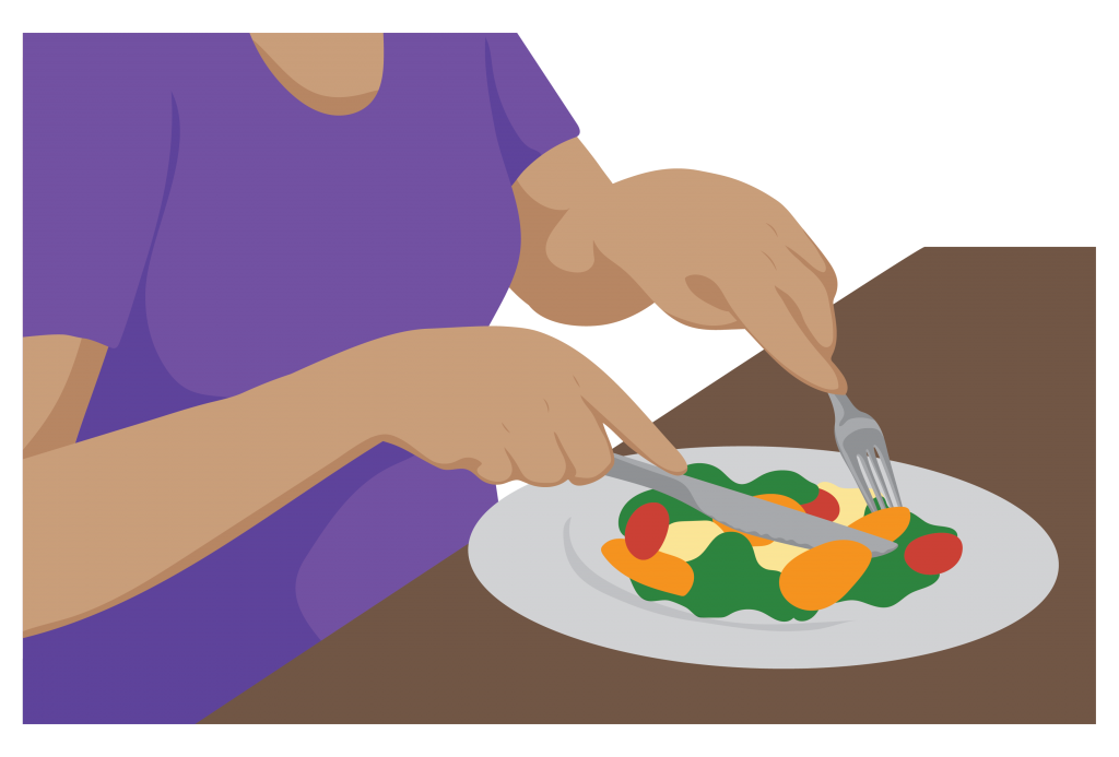 A person uses a knife and fork to cut up their meal.