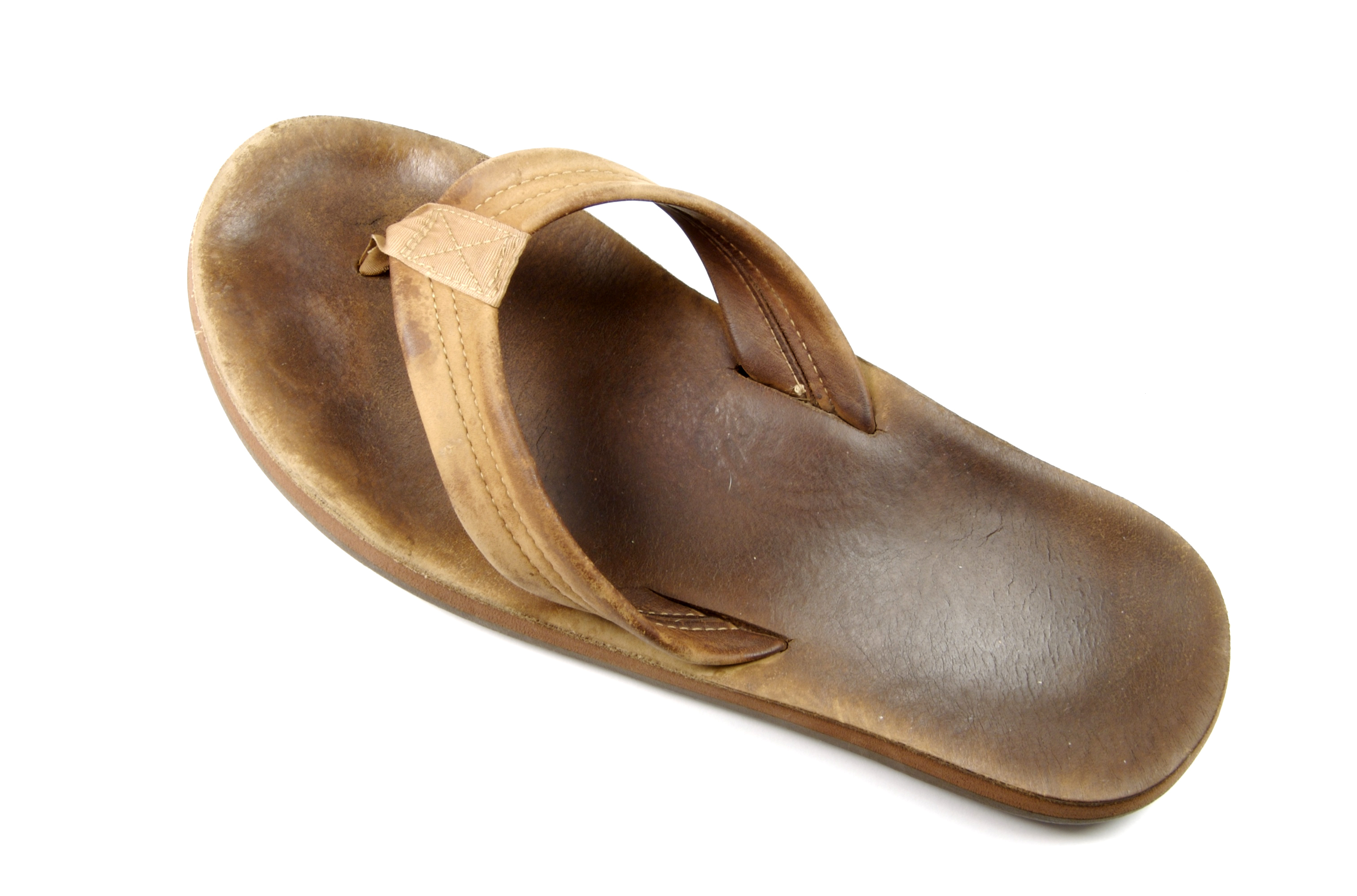 A flat sandal with a thin base and one strap that goes around the front of the foot and can be held between the big and second toe.