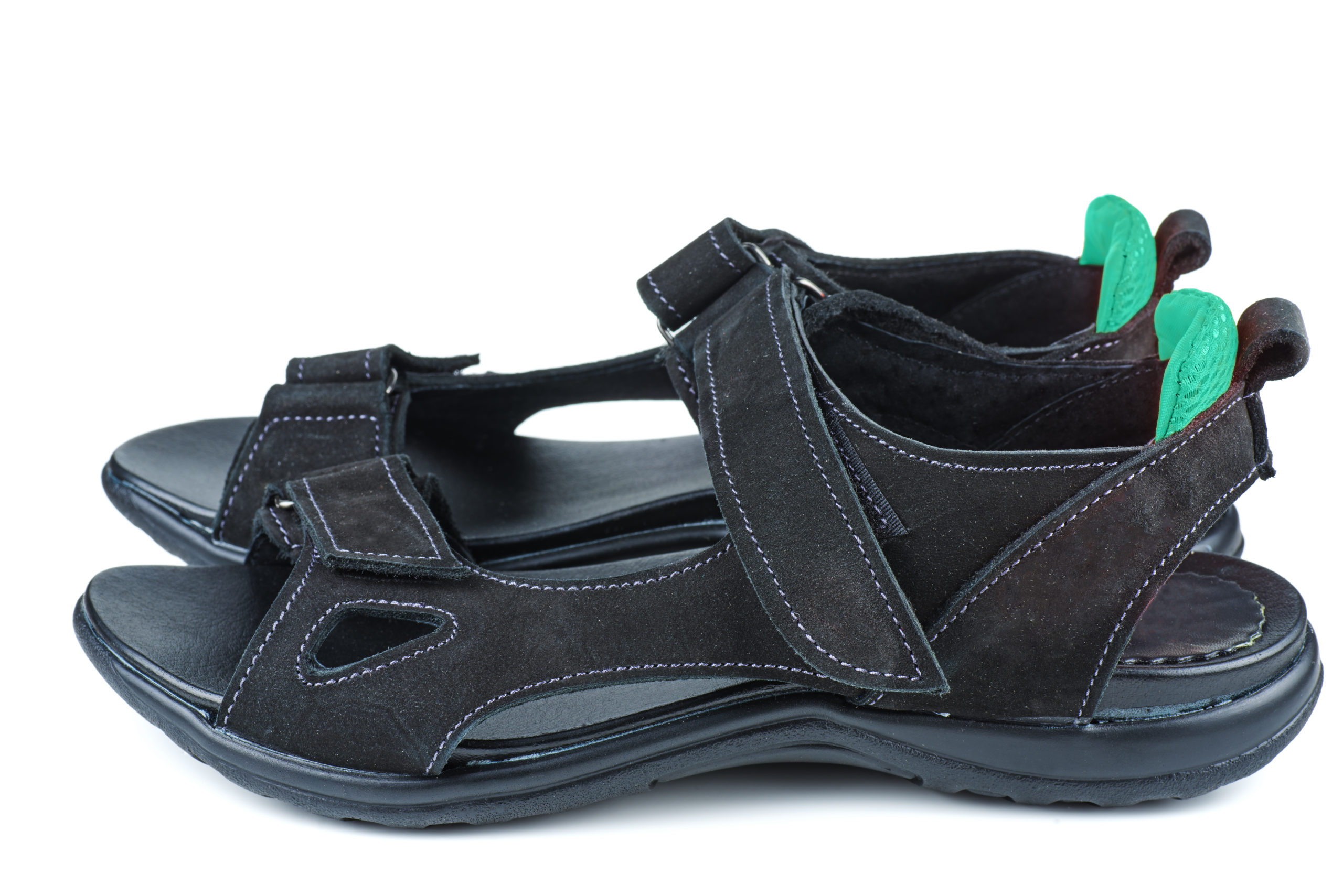 A flat sandal with a thick base shaped to support the foot. Adjustable straps can fit around the front, ankle and back of the foot. The toe space is open and wide.