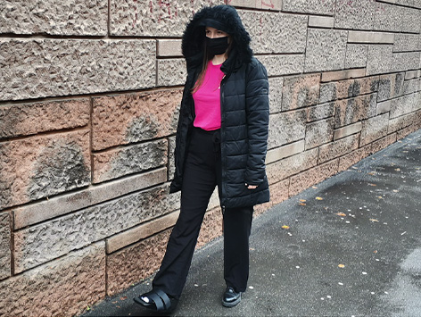 A woman wearing a rigid removeale boot walked down a paved street.