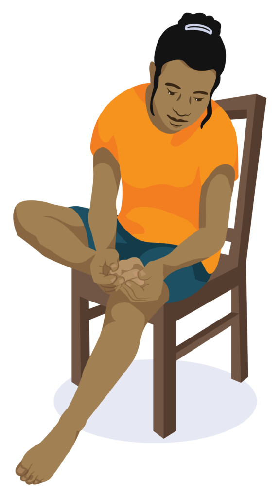 A woman sits and checks the bottom of her feet.