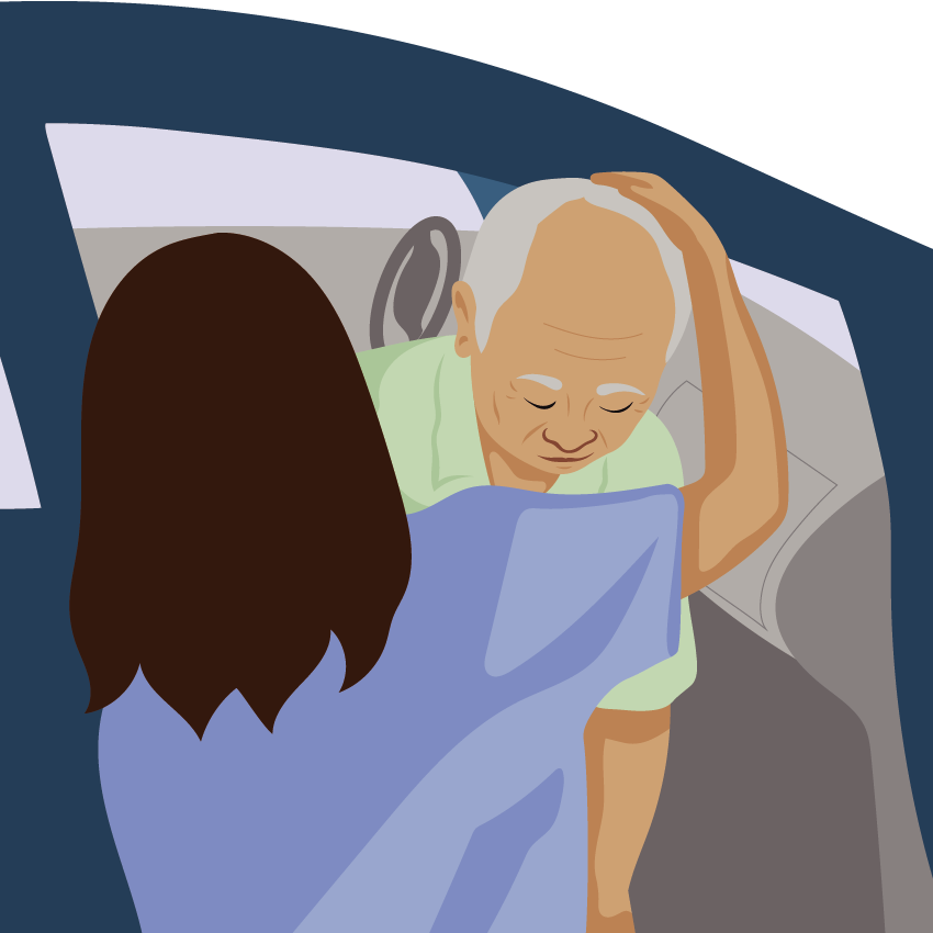 An assistant protects a person’s head from hitting the car as they transfer on to the vehicle seat.