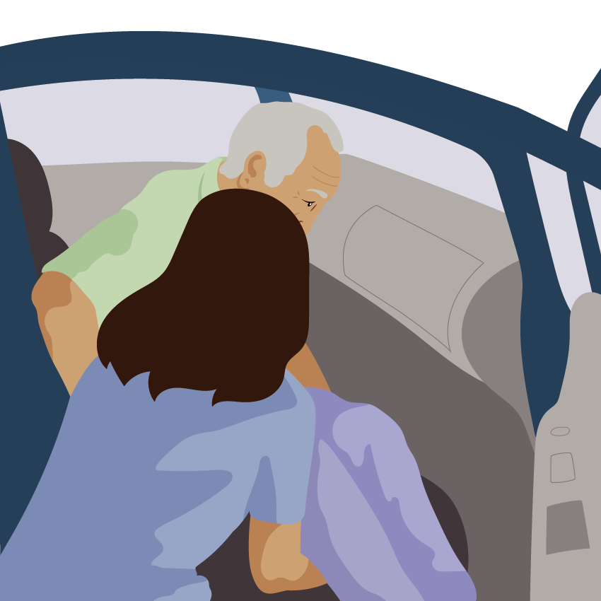 The person lifts their legs in to the vehicle. An assistant gives support under their legs.