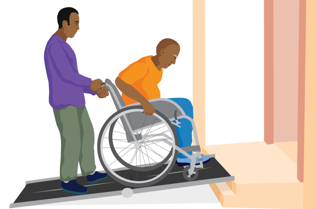 A man using a wheelchair propels up a portable ramp, while another man assists him by holding the push handles.