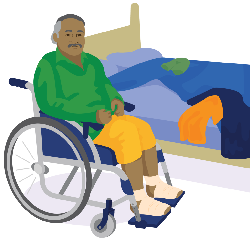 Malu sits in a wheelchair next to a bed which is of a similar height. He has bandages on his feet.