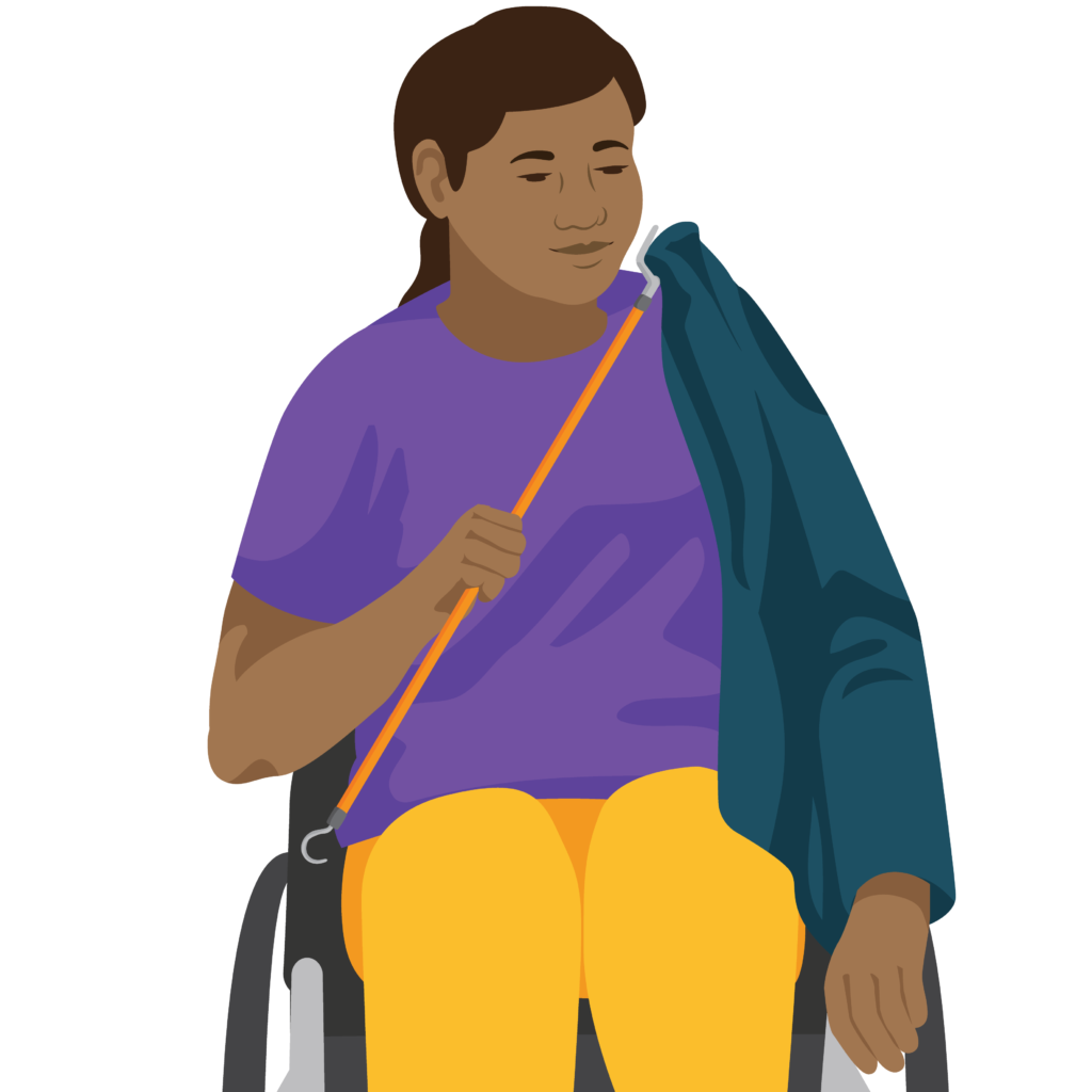 A person sitting in a wheelchair. They hold a dressing stick in their right hand. The s shaped hook lifts the sleeve over the shoulder.